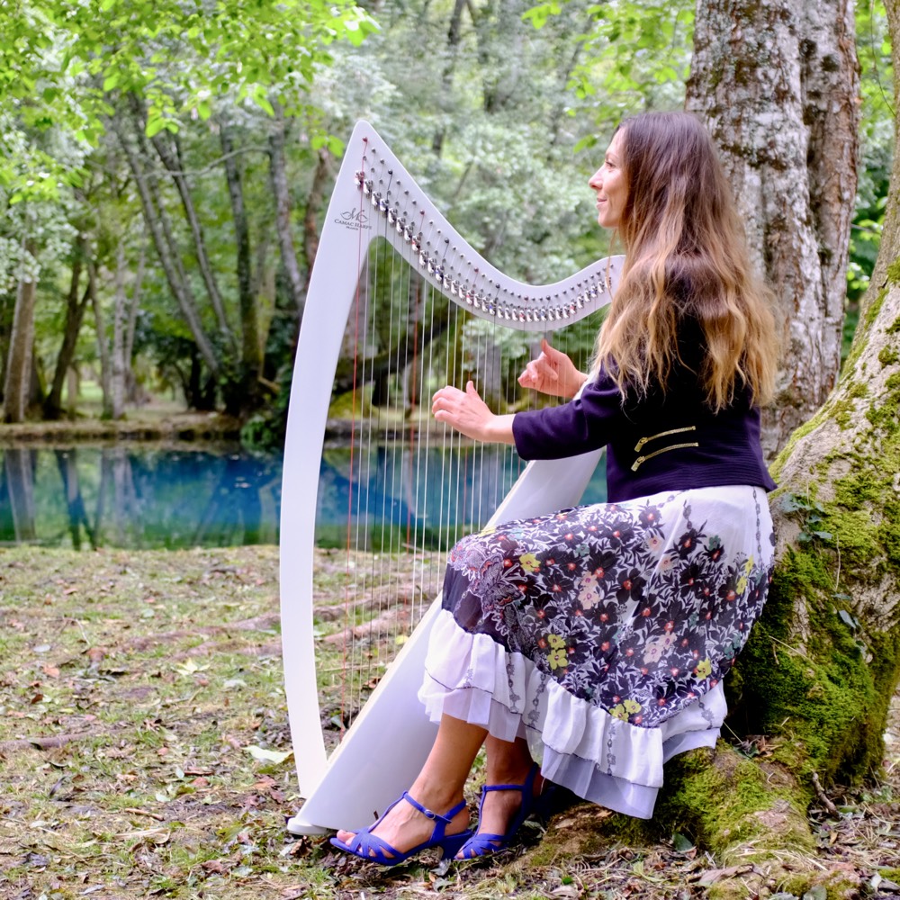 Anaïs jouant de la harpe au bord de l'eau
